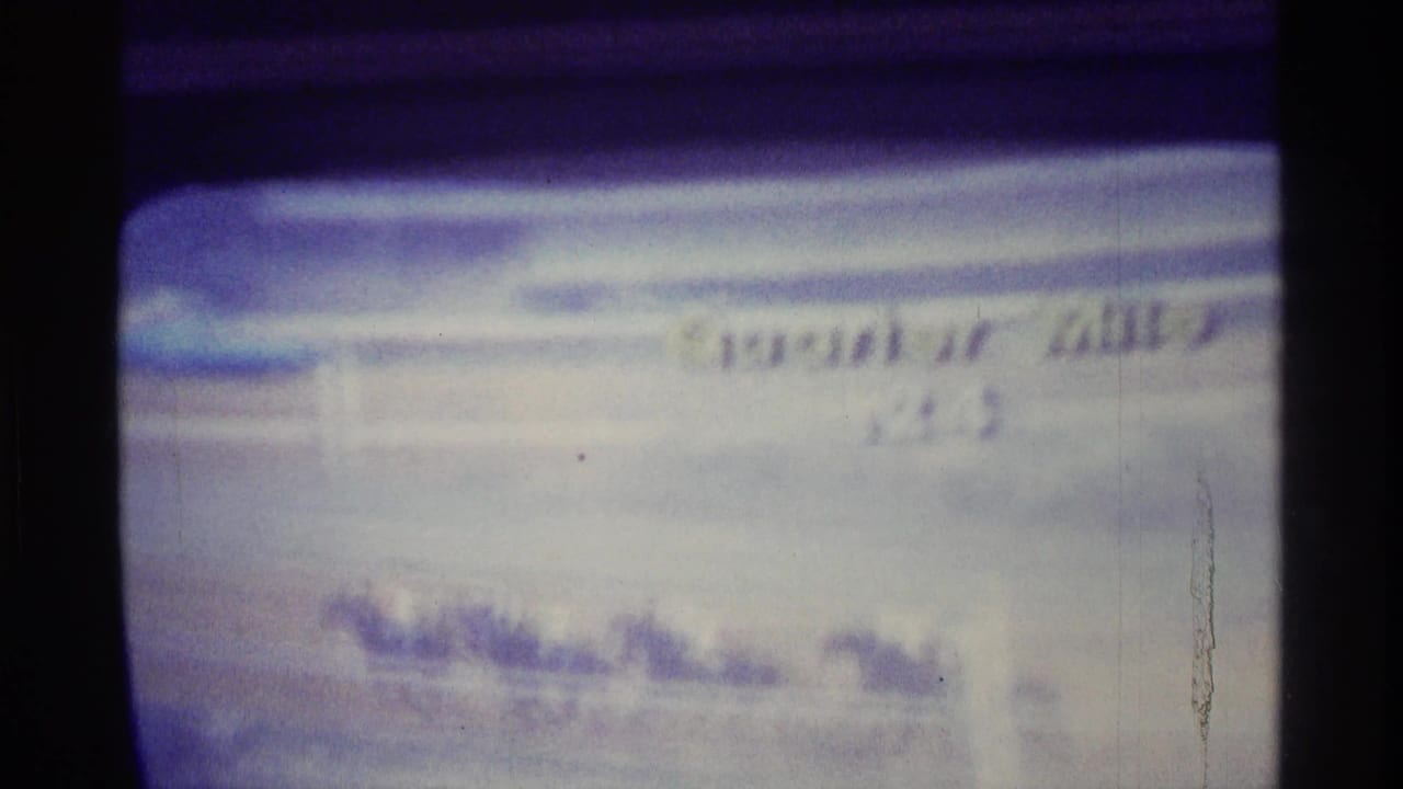 Close view of a CRT television showing horses racing along a track.