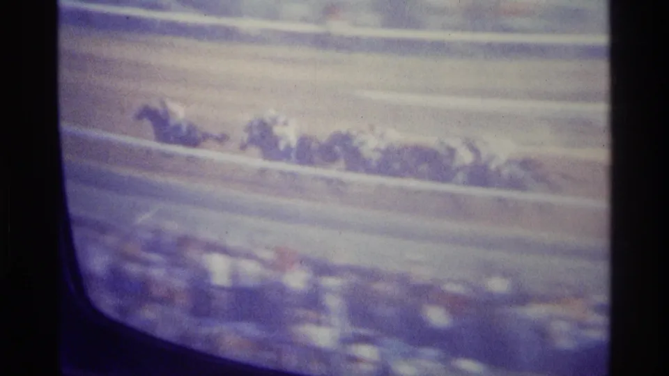 Televised Kentucky horse race with horses along the rail and a blurred crowd area at the bottom of the CRT image.
