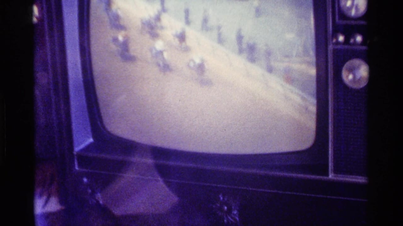 Vintage television set with rounded screen showing blurry snowy footage.