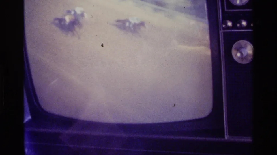 Kentucky 1976 home-movie still of a vintage television screen with a blurry snow scene and prominent chrome tuning dial.
