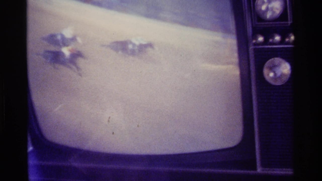Retro television showing a race on a purple-tinted screen.