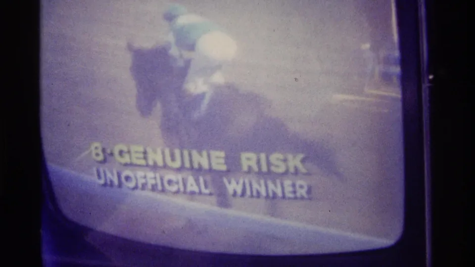 Kentucky 1976 8mm frame of a television showing a racehorse and jockey beside the Genuine Risk unofficial winner text.