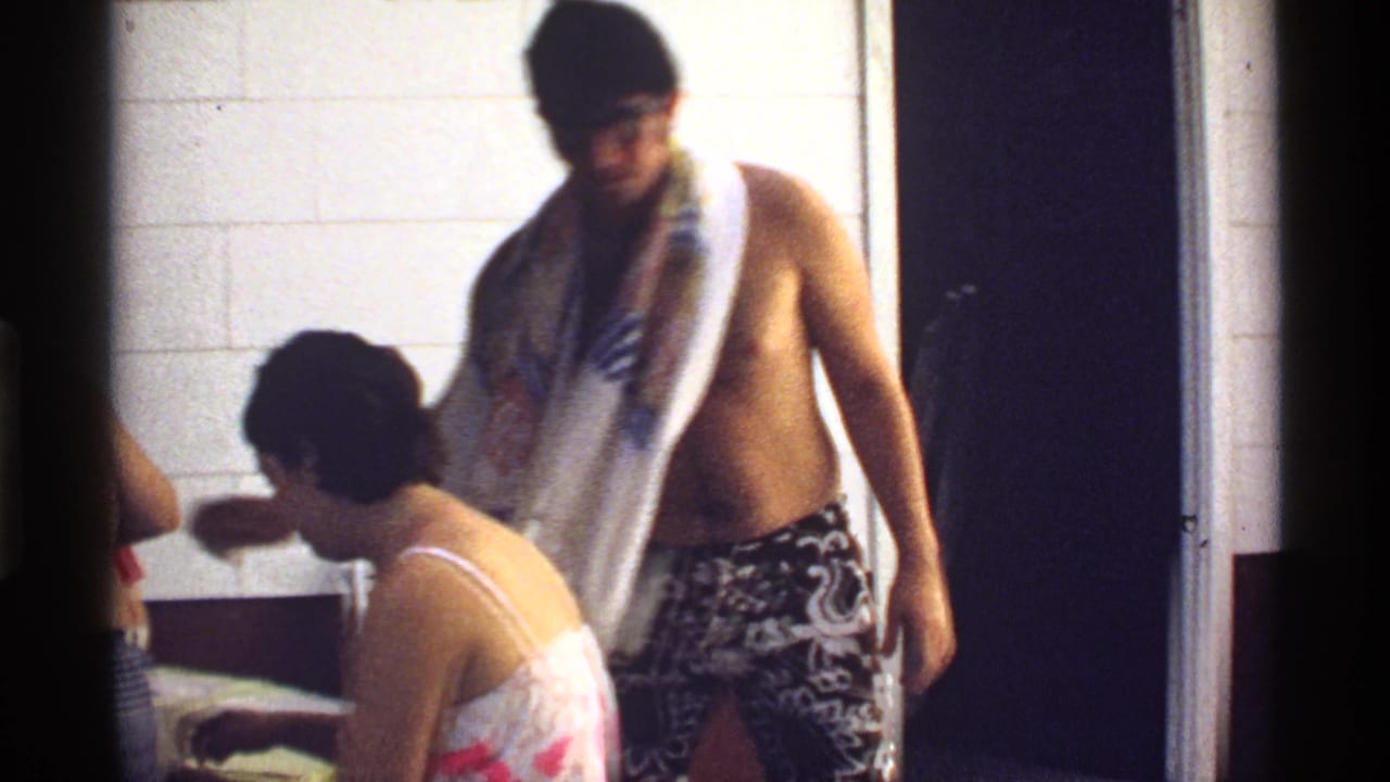 1978 California frame with adults in swimwear moving through a tiled room during a casual private gathering.