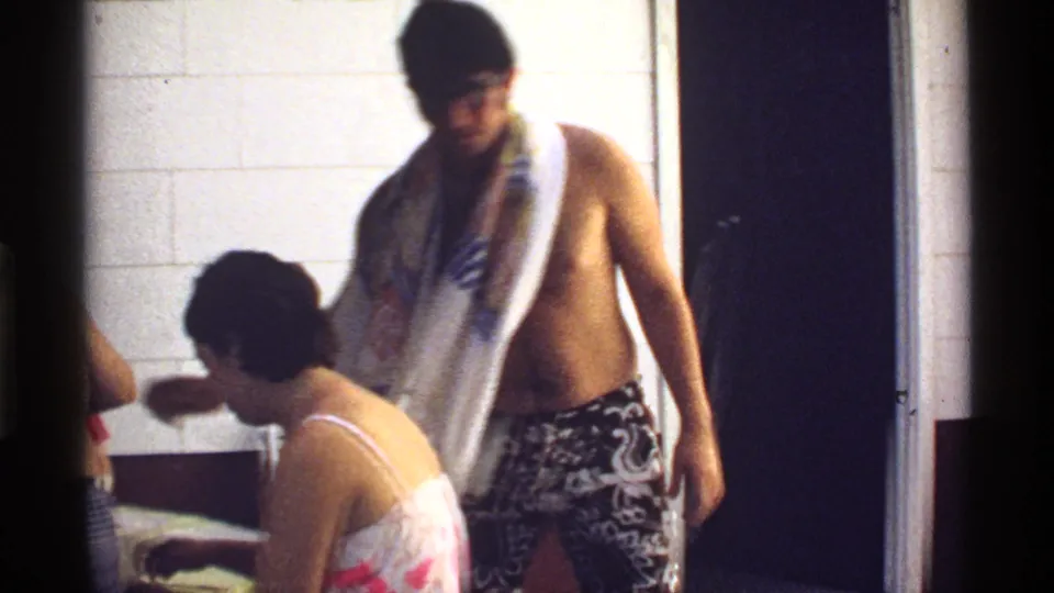1978 California frame with adults in swimwear moving through a tiled room during a casual private gathering.