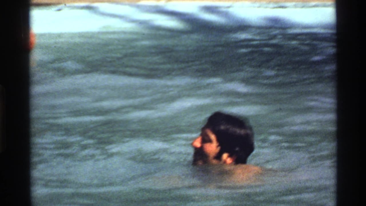 Adult man in profile in a California backyard pool, captured in soft, faded 8mm home-movie footage.