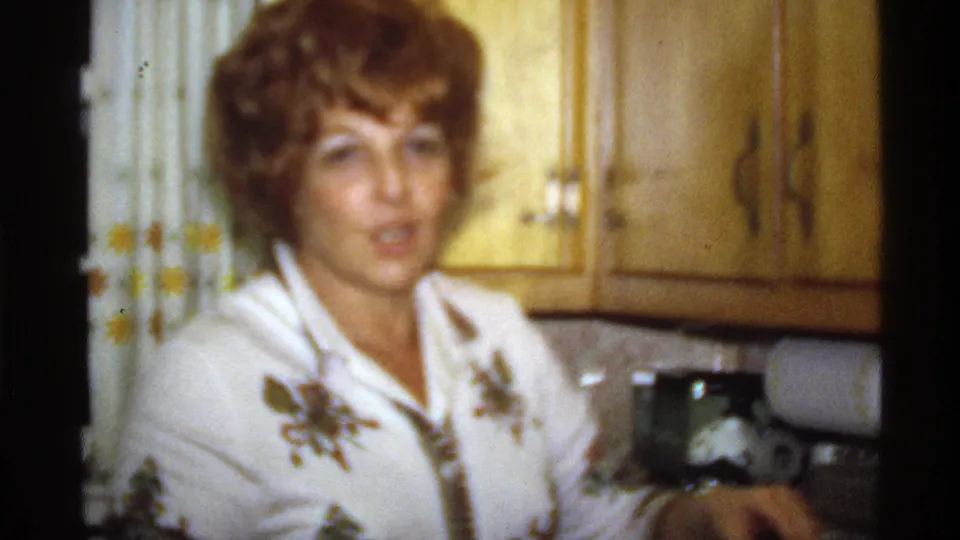 Woman in a white floral blouse appears near a kitchen counter in a 1978 California home-movie frame.