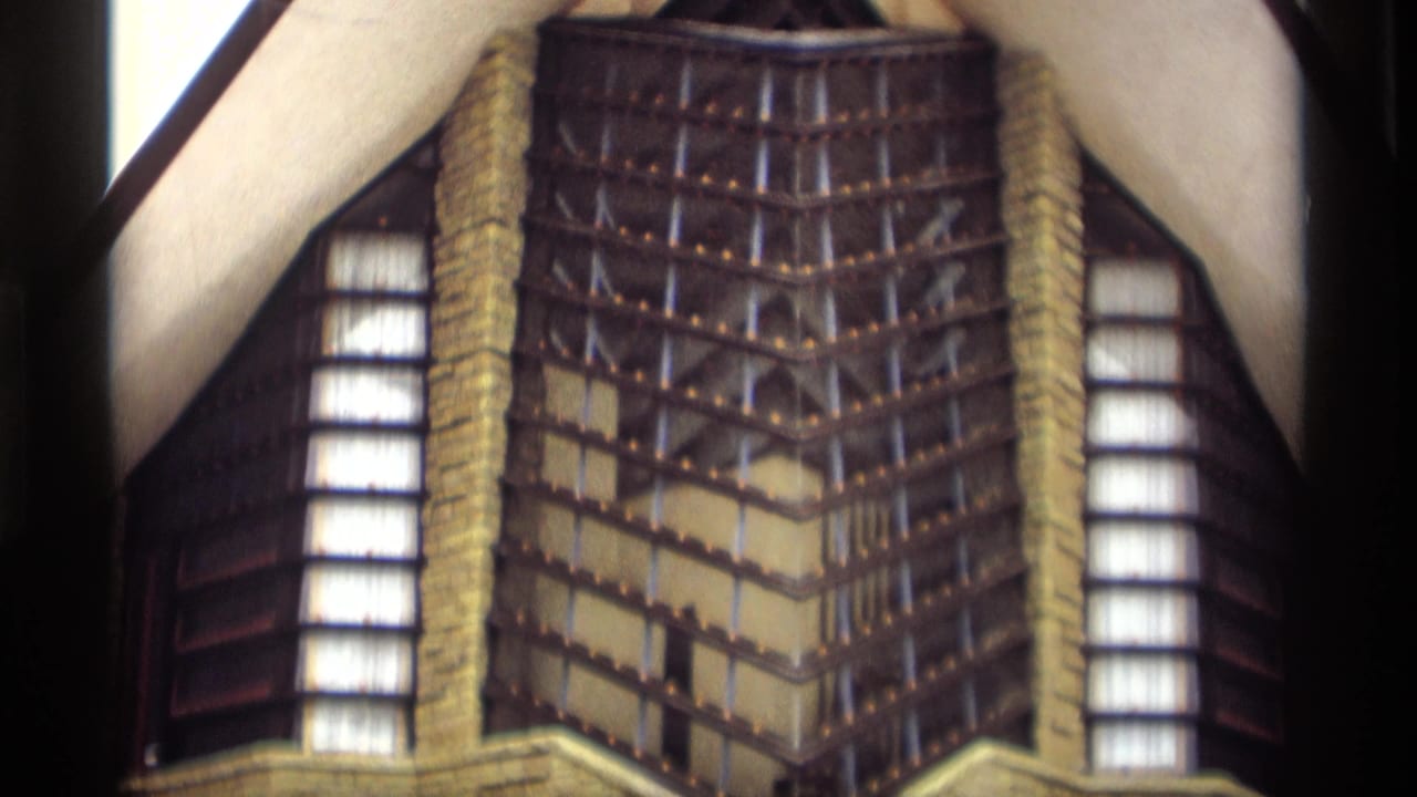 8mm frame of a decorative building facade in Madison footage, with vertical windows, patterned exterior detail, and visible film borders.