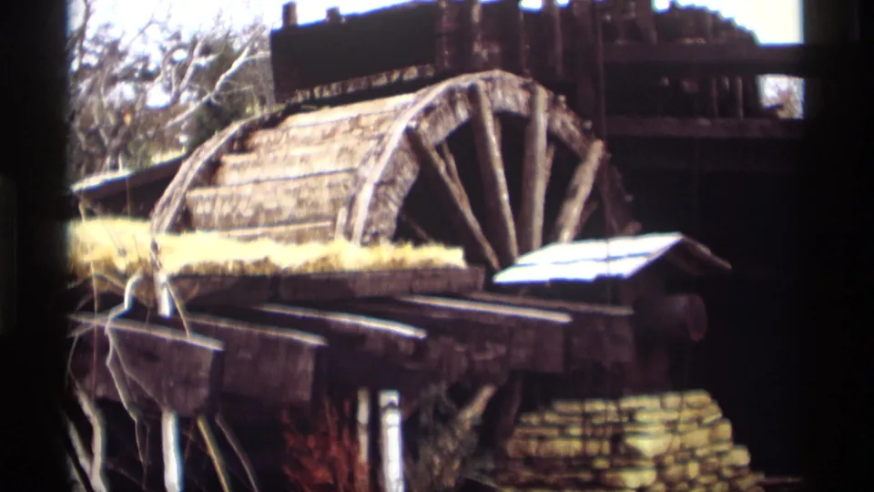 Madison, Wisconsin 1966 footage holds on a weathered mill wheel, rough timber, stone base, and winter-bare trees.
