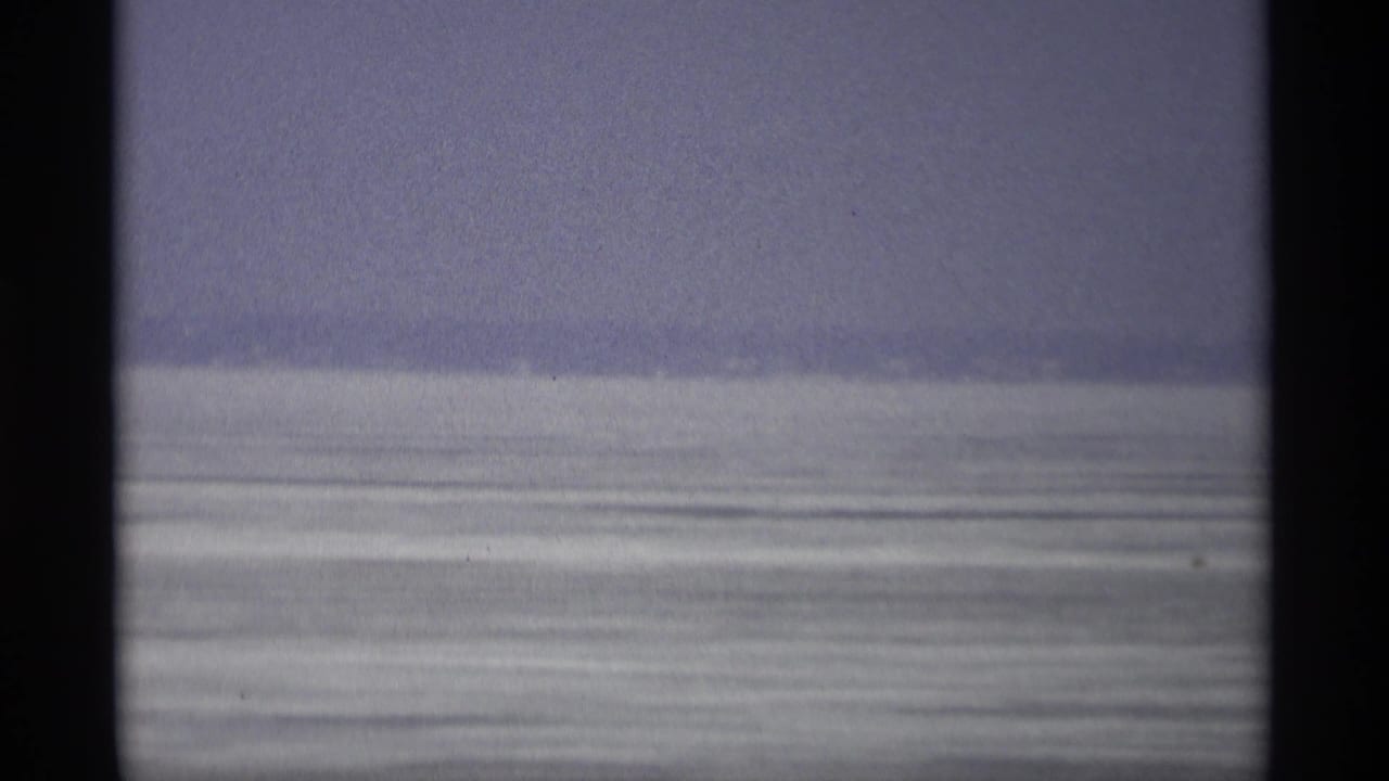 1966 Madison home-movie frame showing a pale frozen field or water surface beneath an overcast sky.
