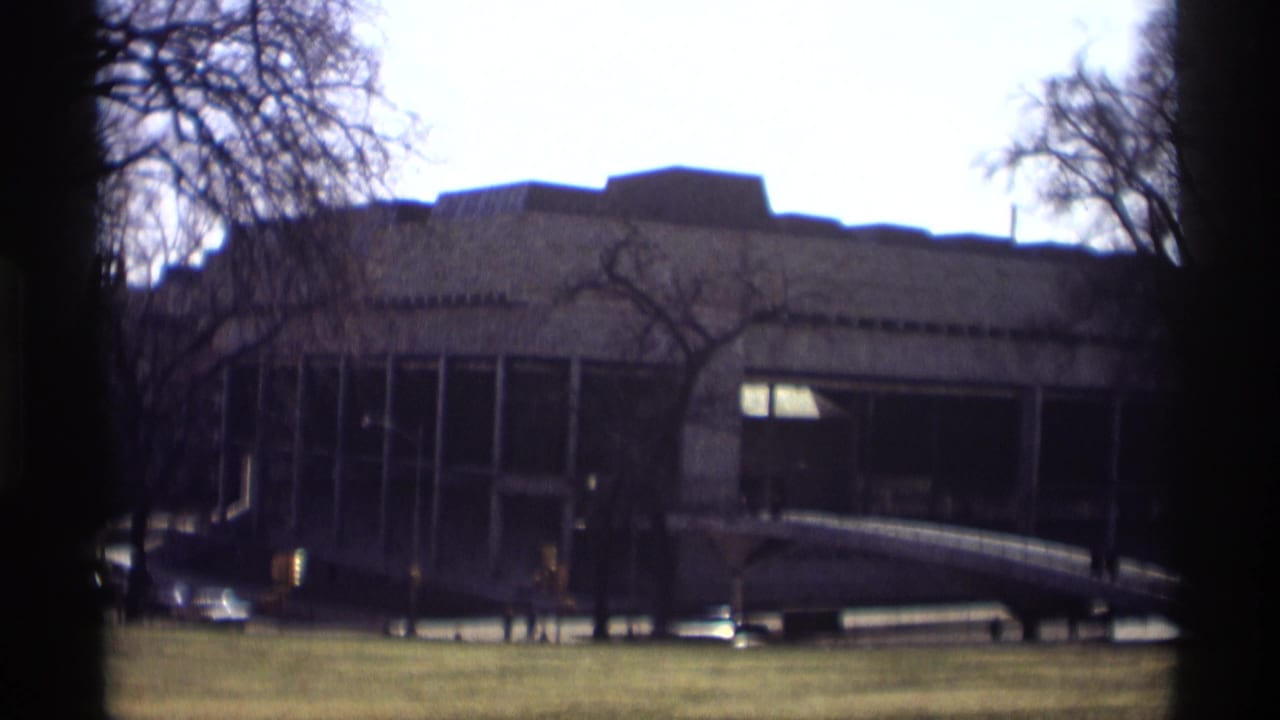 1966 Madison view of a modernist concrete-and-glass building seen across a lawn through leafless trees.
