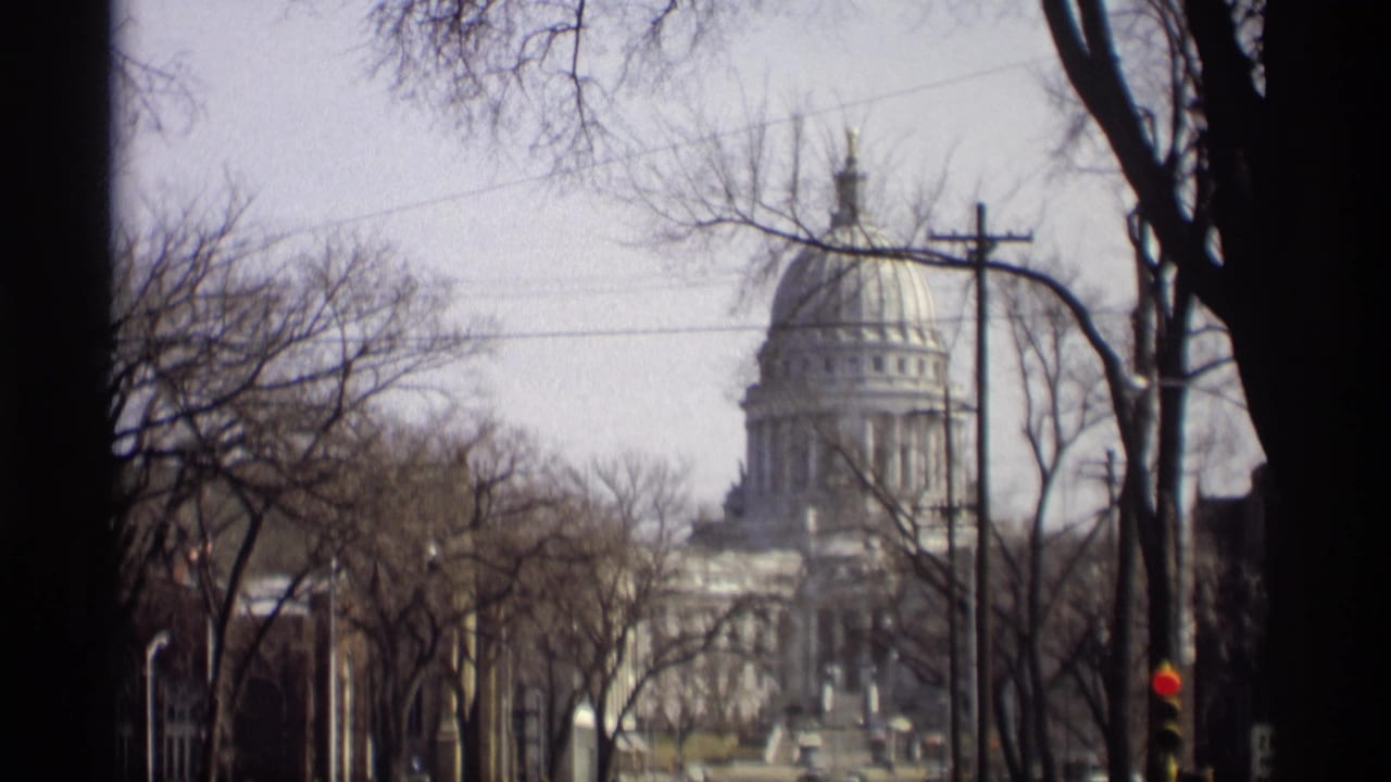 Madison street view of the Wisconsin State Capitol dome and facade, softened by 8mm grain and motion blur.