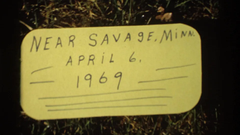 Handwritten yellow card on grass identifies the scene as near Savage, Minnesota, dated April 6, 1969.