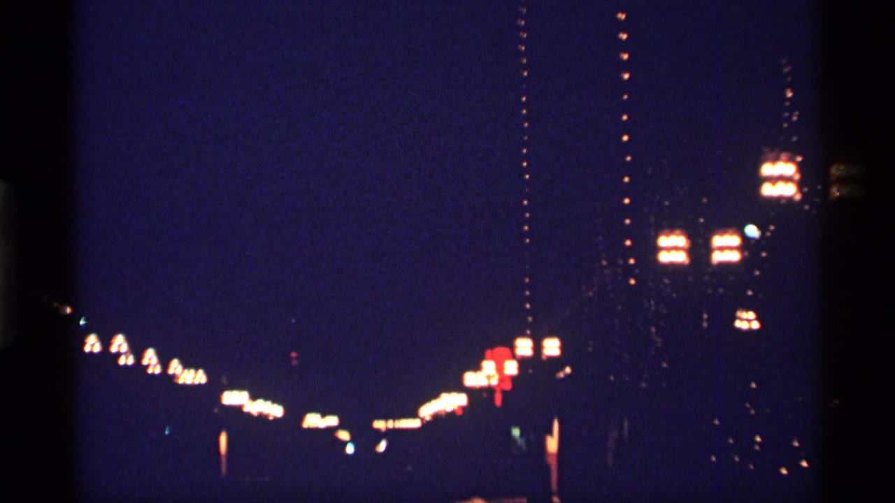 Blurred nighttime city lights against a dark blue sky.