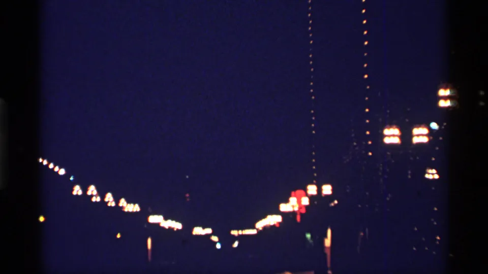 Underexposed 8mm frame of Chicago night lights, seen from a moving vehicle in 1968.