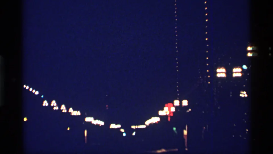 Chicago nighttime city-light frame from 1968 8mm home-movie footage, with no identifiable people or signage.