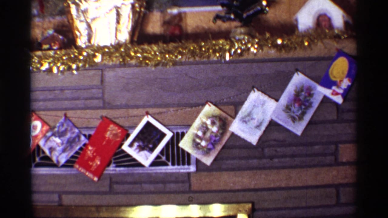 Holiday cards and mantel decorations above a stone fireplace.