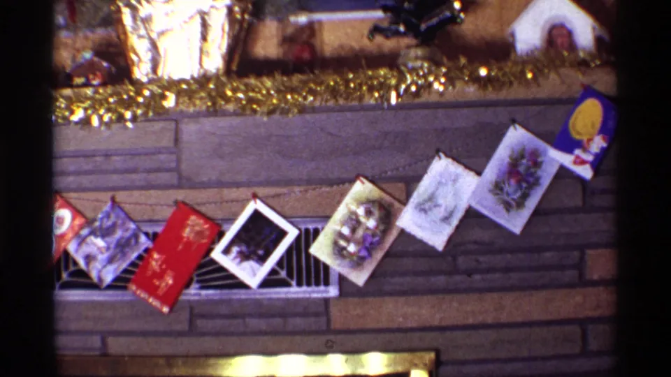 1968 Chicago interior frame with a row of Christmas cards clipped across the fireplace and gold garland decorating the mantel above.