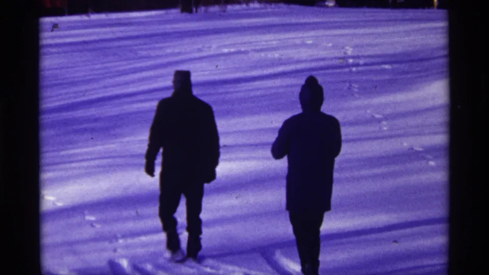 A 1968 Chicago winter frame shows two bundled figures walking apart across a snowy yard.