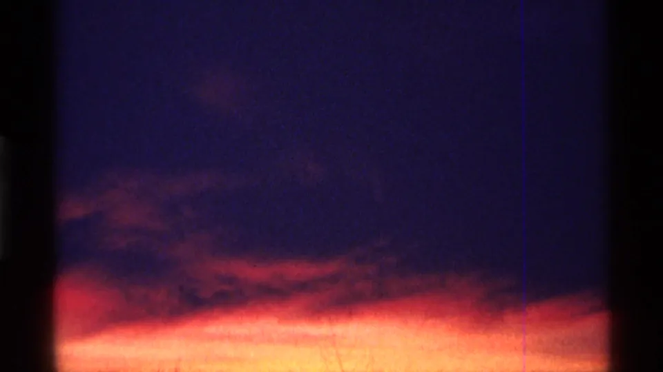 Chicago-attributed 1968 8mm sunset frame with glowing clouds, blue-purple sky, and prominent film gate edges.