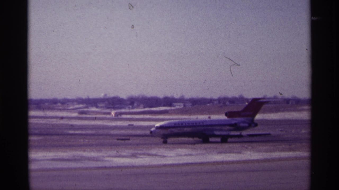 Northwest Airlines jet taxiing on a snowy airport surface under a pale sky.