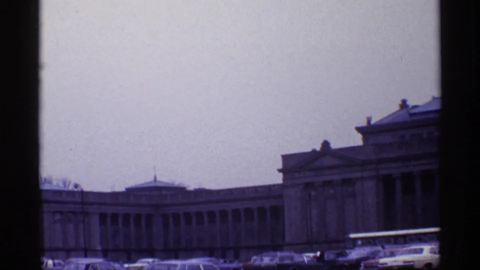 Wider 1968 Chicago view showing a neoclassical building complex with low dome, columns, cars, bus, and small figures near the curb.