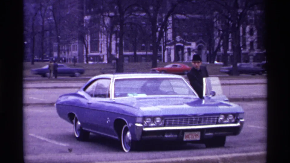 The final frame shows the man beside the blue Chevrolet Impala in the supplied Chicago setting, with red and dark cars passing behind.