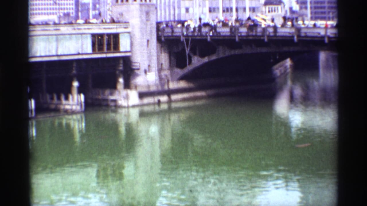 Chicago bridge scene from 1968 showing a busy span, distant pedestrians and vehicles, stone bridge elements, and soft river reflections.