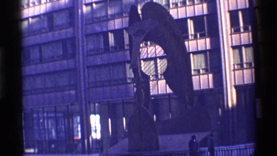 1968 Chicago frame showing a silhouetted abstract sculpture, high-rise windows, railings, and a small distant pedestrian.