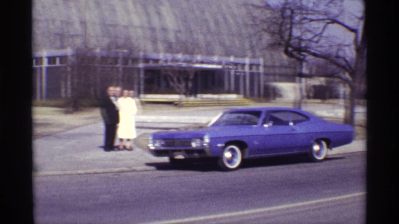 In 1968 Chicago footage, a formally dressed couple poses near a purple classic car outside Garfield Park Conservatory.