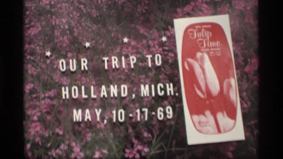 1969 Holland, Michigan trip title arranged near pink tulips, with a visible Tulip Time program at right.