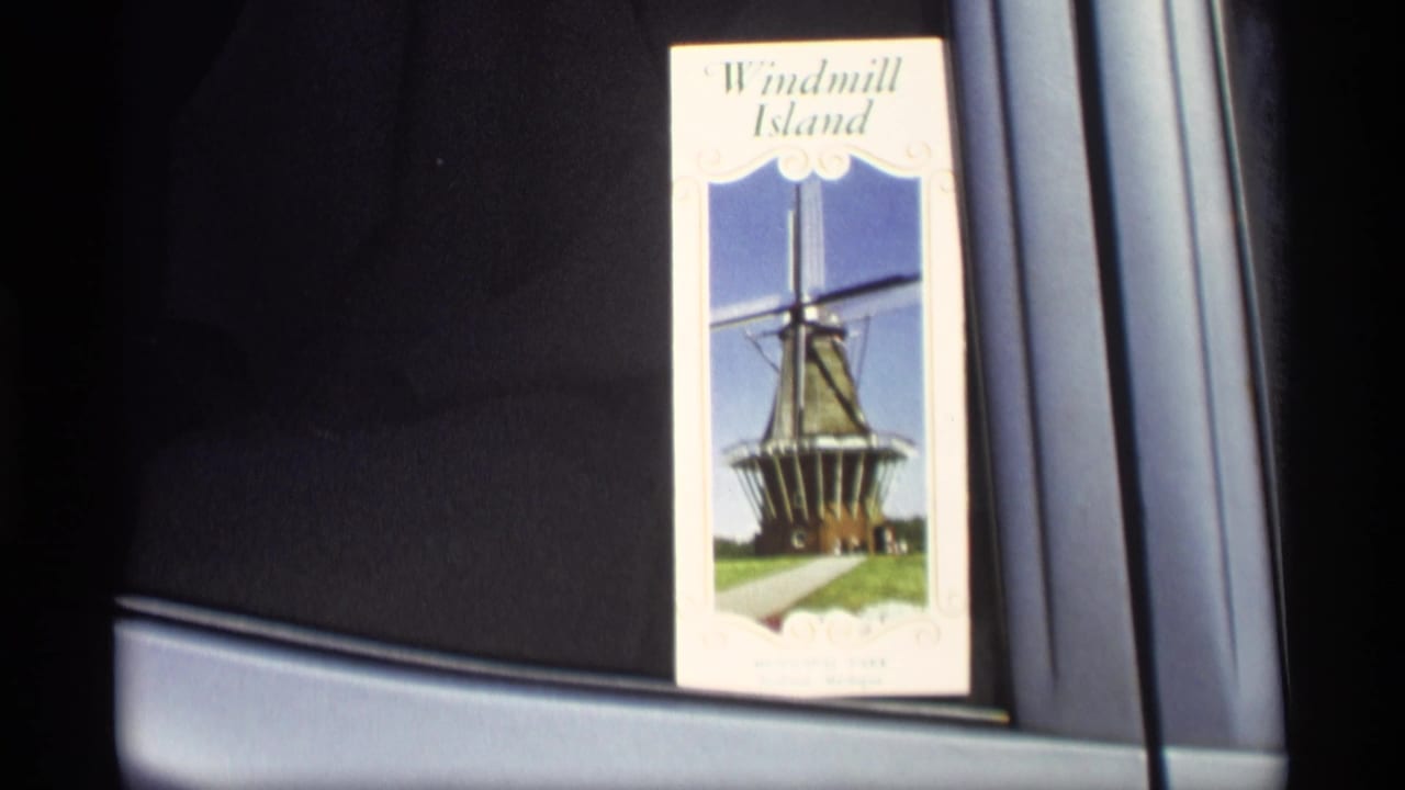 Close-up of a Windmill Island brochure beside a car window or interior trim.