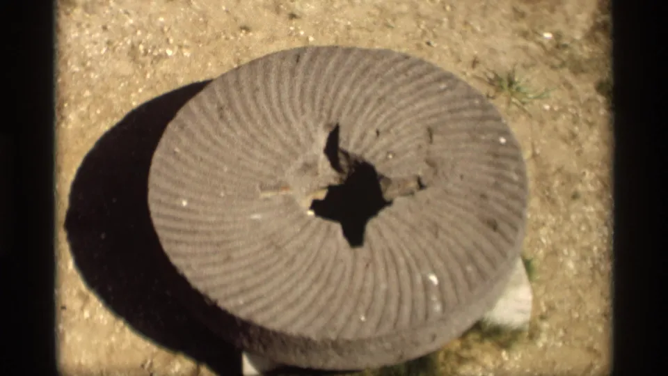 Close 8mm view of a weathered circular cement disk in sunlight, recorded in Holland, Michigan in 1969.
