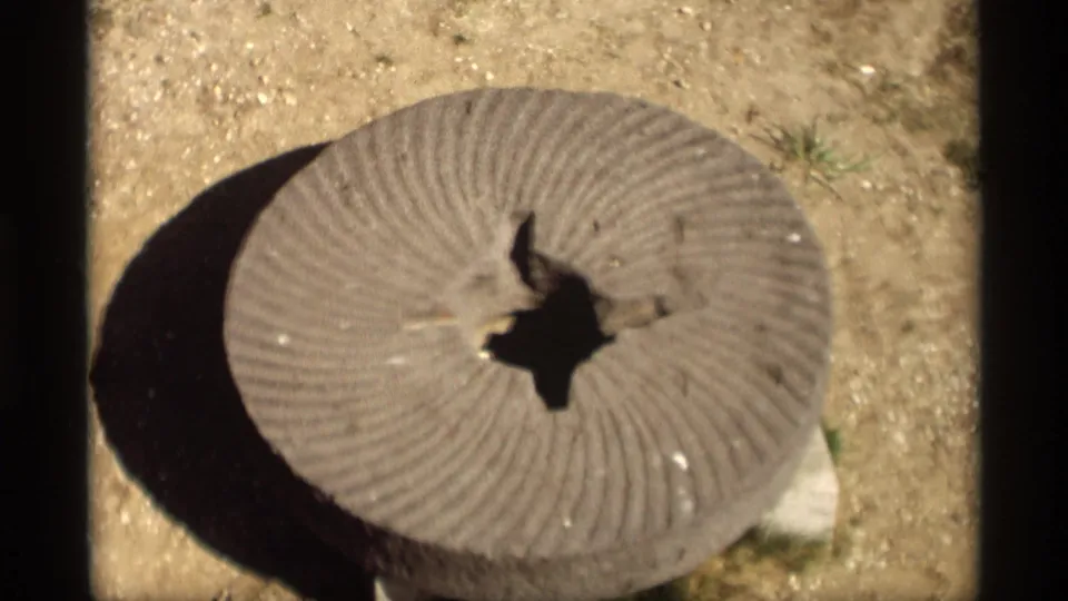 Visitor-shot 1969 frame of a grooved cement disk on sandy ground at a Holland, Michigan windmill location.