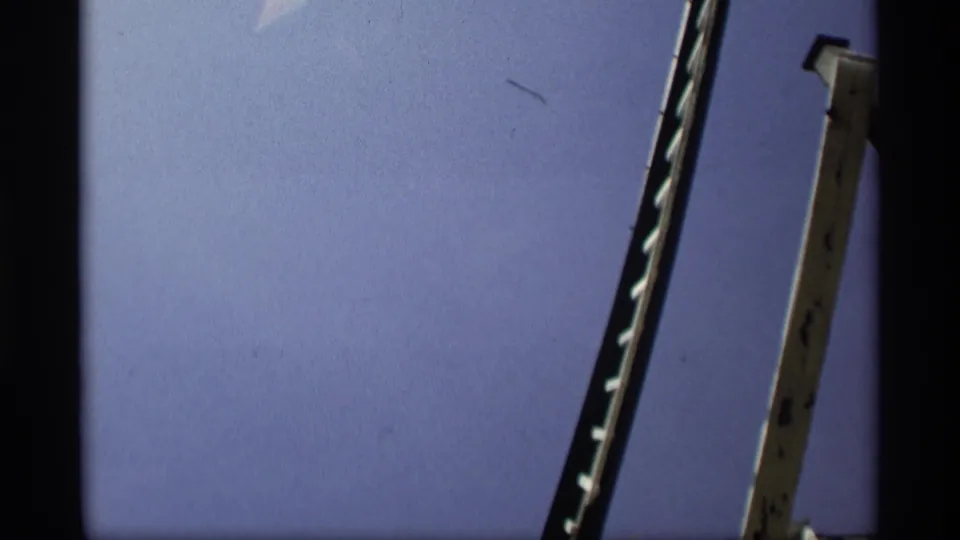 1969 Holland, Michigan 8mm frame looking upward at part of a windmill structure against blue sky.