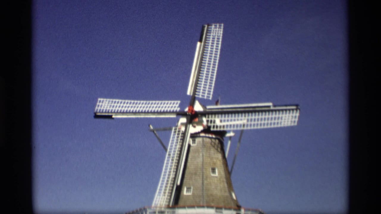 1969 Holland, Michigan frame of the windmill with its sails shifted in rotation, filmed from a low visitor perspective.