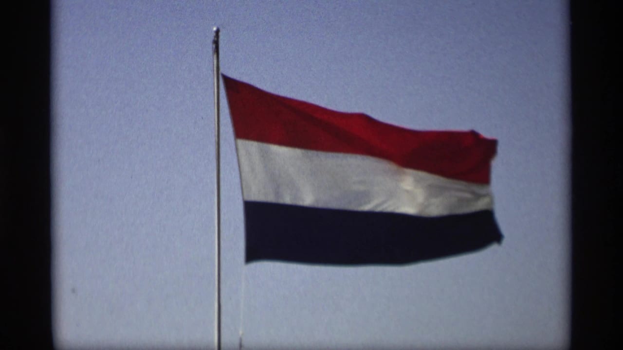 Netherlands flag waving against a blue sky in supplied 1969 Holland, Michigan 8mm home-movie footage.