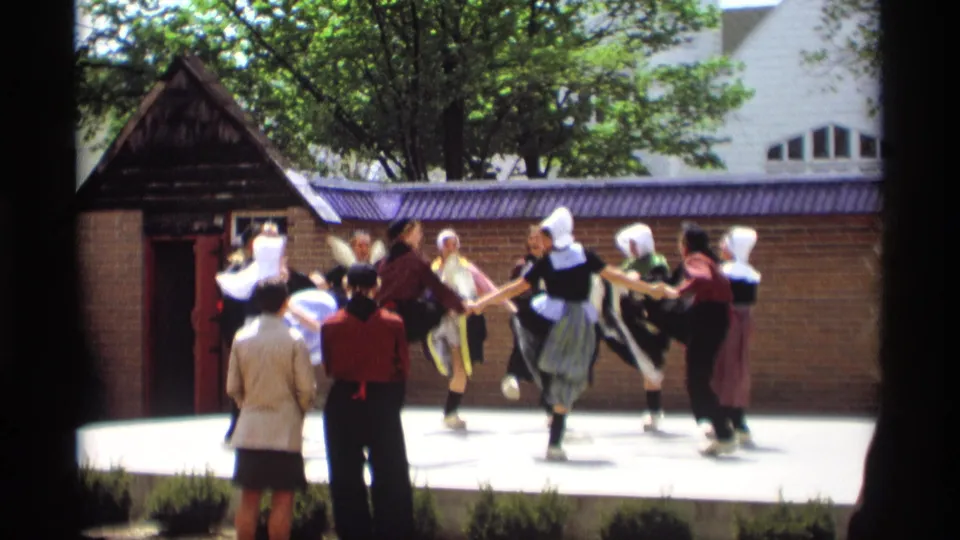 At the end of the clip, Dutch-style costumed performers kick in unison on a sunlit Holland, Michigan stage in 1969.