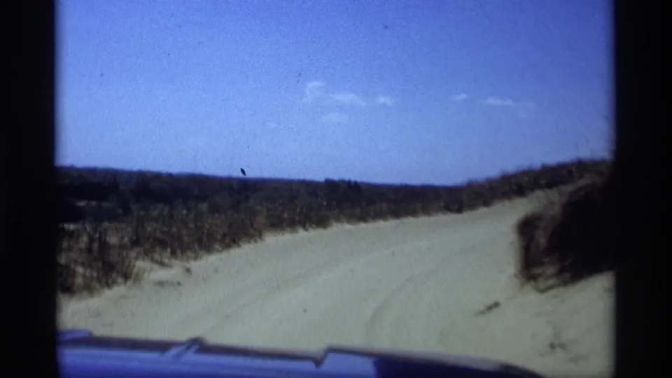 Final 1969 8mm frame looking over the car hood along a sandy dune road near Holland, Michigan.