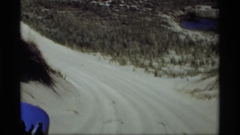Vehicle-mounted or passenger view of a winding sandy dune road in Holland, Michigan, with the blue car edge visible below.