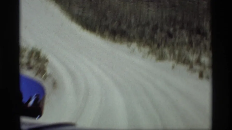 1969 in-car home-movie frame showing a sandy dune road curving through low vegetation near Holland, Michigan.