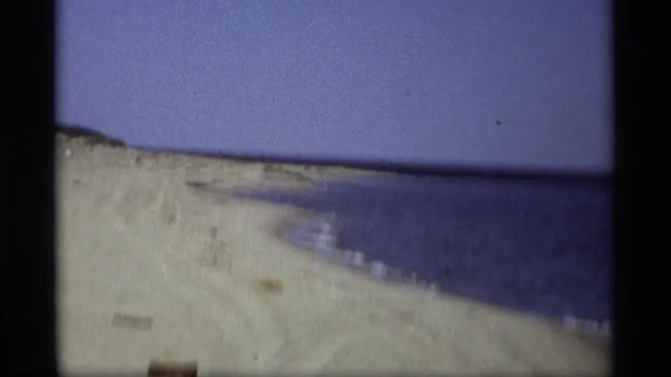 Holland, Michigan beach footage from 1969 shows a curving sandy shoreline and broad calm water in soft 8mm color.