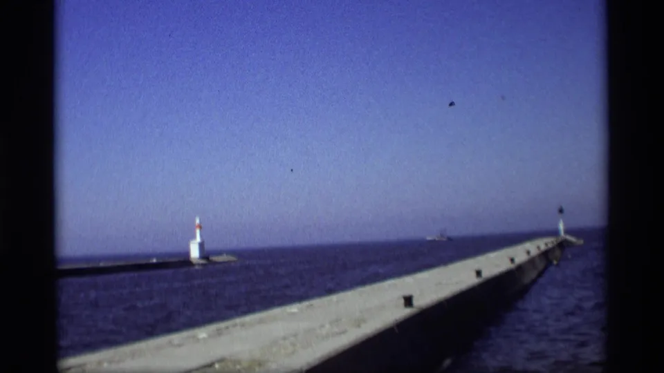 1969 Holland, Michigan home-movie view of the pier, small lighthouse, open lake, and distant horizon.