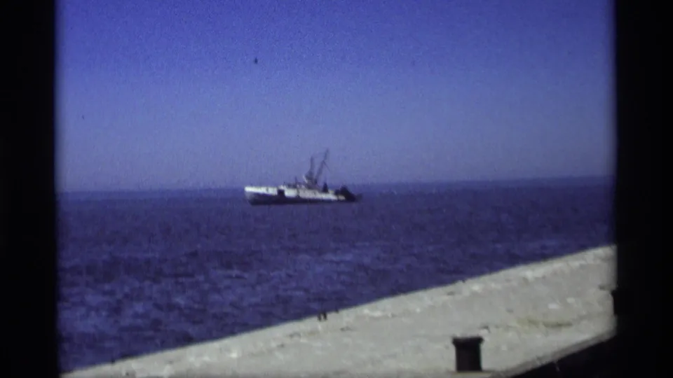 1969 Holland, Michigan frame showing a fishing boat offshore beyond the concrete pier edge.