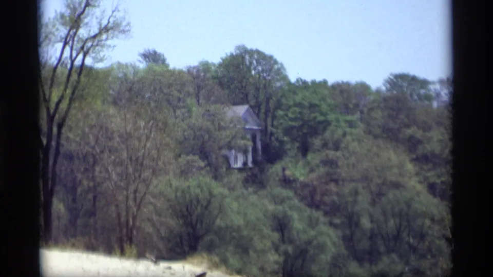 A distant house or structure appears partly obscured by trees, likely along the scenic Holland, Michigan tour route in 1969.