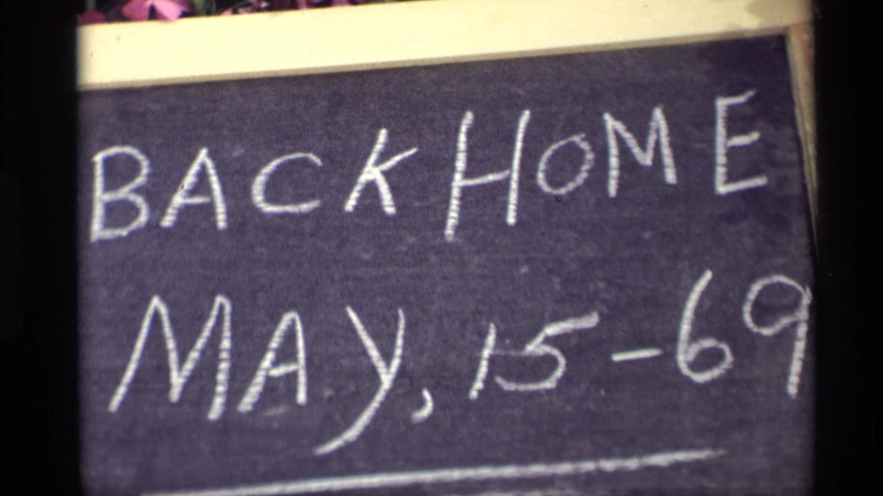 Close 1969 8mm frame of a handwritten Back Home May 15-69 chalkboard sign in Holland, Michigan.