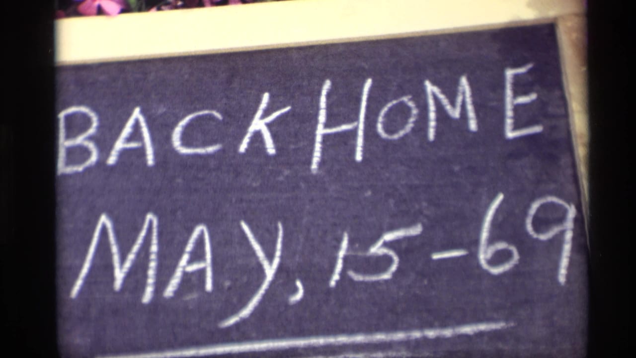 Chalkboard sign with BACK HOME and MAY, 15-69 filling the frame.