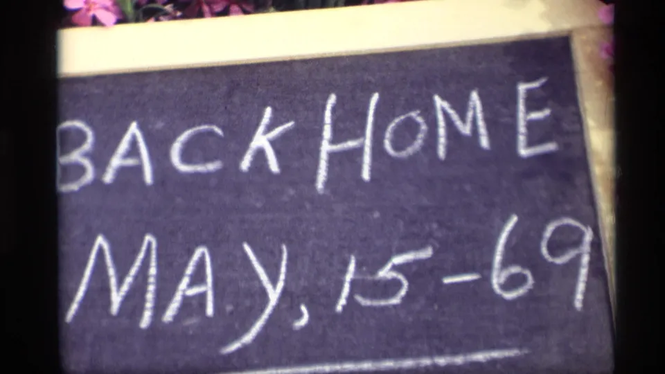 Angled close-up of the Back Home May 15-69 chalkboard sign on 8mm film from Holland, Michigan.