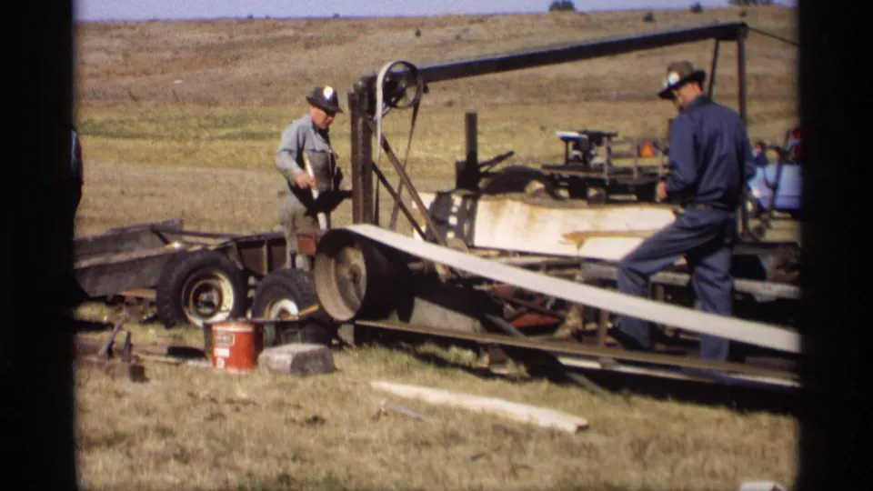 The final frame shows the men still working around the trailer-mounted band saw and long wooden slat in the 1969 Jordan, Minnesota field scene.