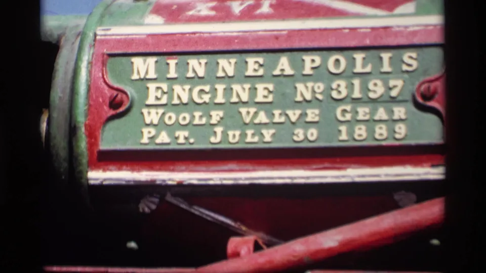 Tighter home-movie view of the Minneapolis Engine No. 3197 plate, with red and green painted metal filling the frame.