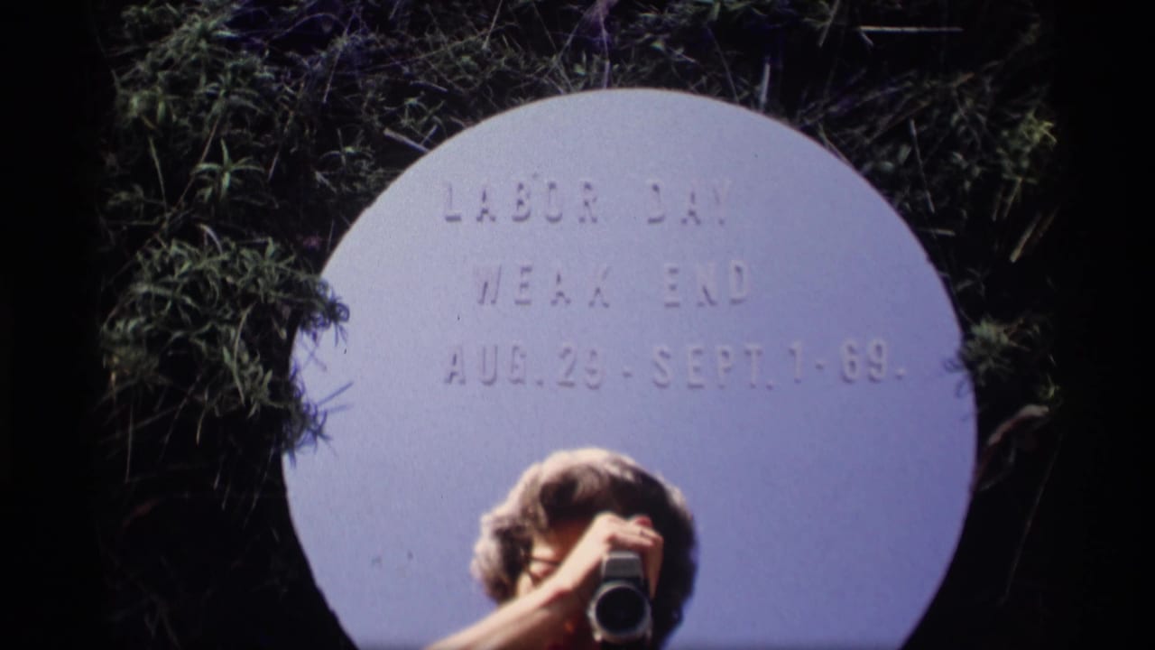 Circular Labor Day weekend sign partly obscured by a person holding a camera.